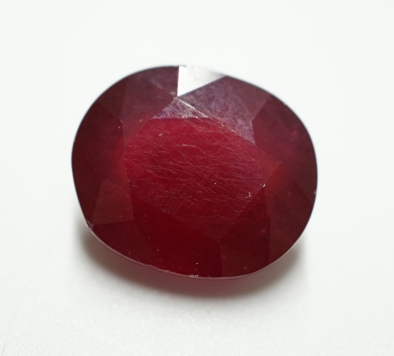 An unmounted oval cut ruby, weighing approximately 11.80ct. Condition - fair